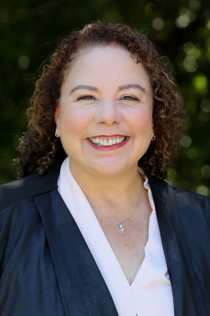 Portrait of Tonya Gonzales-Clenney, smiling, outdoors in natural light
